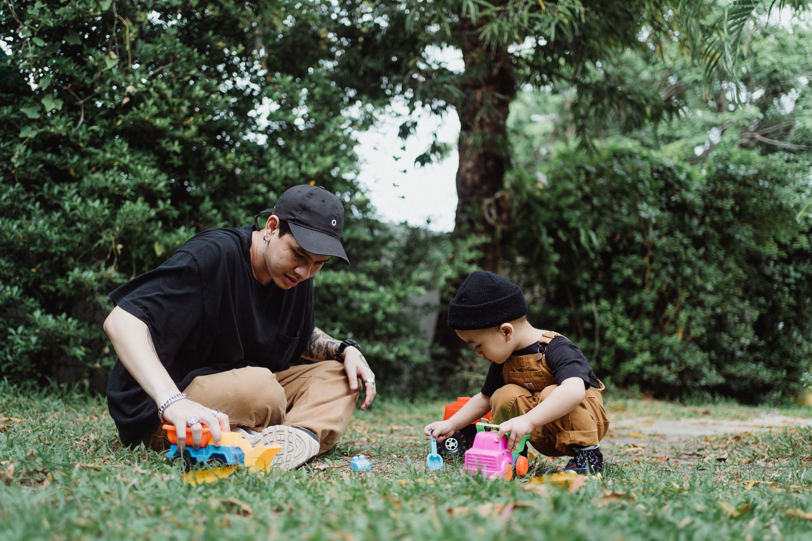 A father and his young child playing together at a park